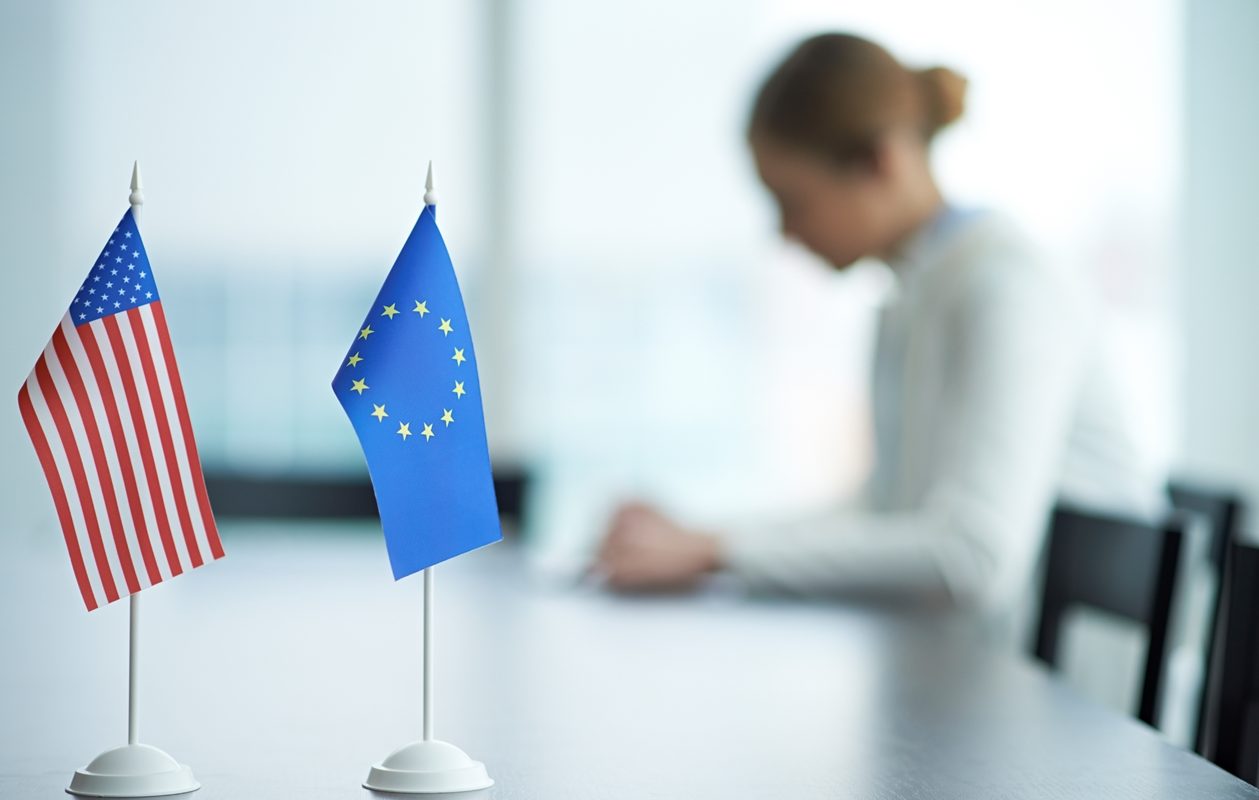 EU and U.S. flags on a desk